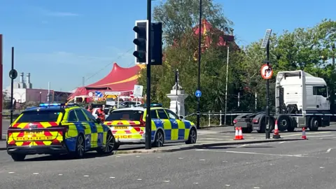 Police cars outside Southampton's Red Funnel terminal with traffic lights and a HGV.