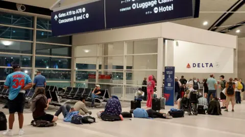 Getty Images Tired passengers at Detroit's airport