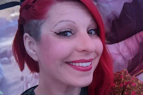 Kirsty Hopley Kirsty Hopley, a woman with red hair, smiles for the camera.