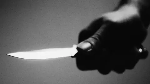 A knife being held in a hand.