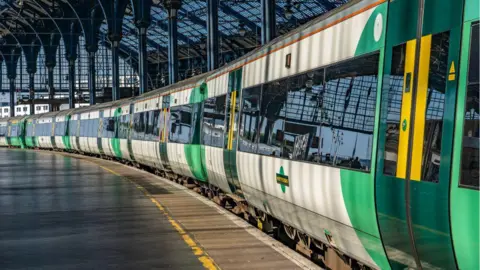 A Southern train at a standstill at a platform at Brighton station. There are no passengers next to the train. 