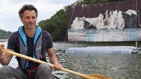 Jimmy Swindells Photography Anthony Garratt rowing near one of the paintings