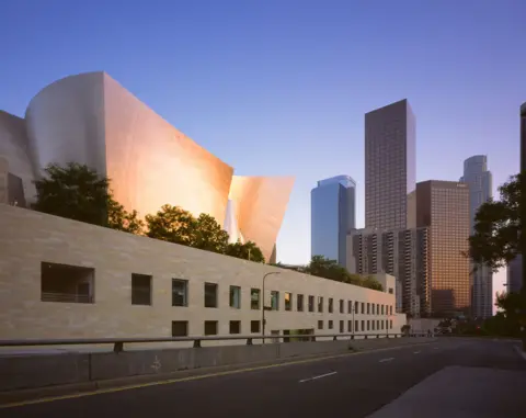 View Pictures/Universal Images Group via Getty Images The Walt Disney Concert Hall in Los Angeles is seen from the street outside and juxtaposed with the imposing skyscrapers on central LA