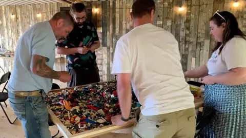 Amber Gash / BBC Members of the group building a Lego model