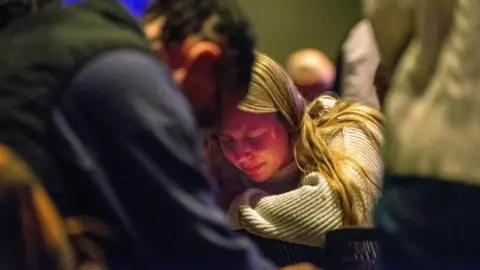 Reuters Worshipers at Blackhawk Church gather to pray for victims and survivors of a shooting at Madison's Abundant Life Christian School, in Middleton, Wisconsin, December 16, 2024.