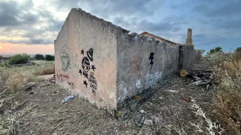 A deserted building with writing on the walls on it