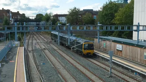 A general view of Newbury station, with a train carrying another carriage at the platform.