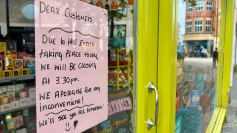 A notice is placed in a shop window apologising for its closure.