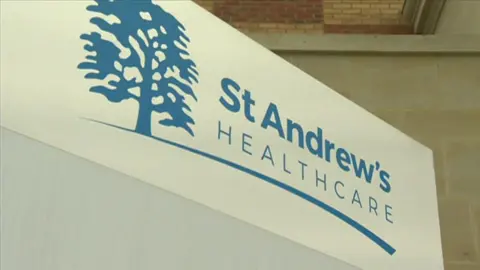 The blue and white logo of St Andrew's Healthcare with a blue tree in the left hand corner.