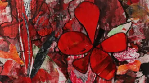 Phil Batty A red floral collage which includes a number of different textures. A poppy like flower is centre with petal like drawings accompanying.