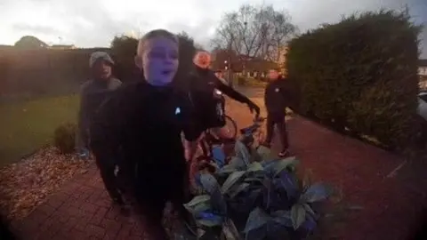 Erin Chalmers Four boys dressed in black, on a bike, captured on a doorbell video.