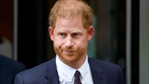 Getty Images Prince Harry, Duke of Sussex, pictured in a dark suit against a black backdrop
