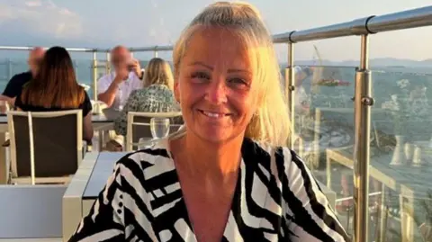 Anita Rose of Suffolk Police wears a black and white dress and smiles at the camera