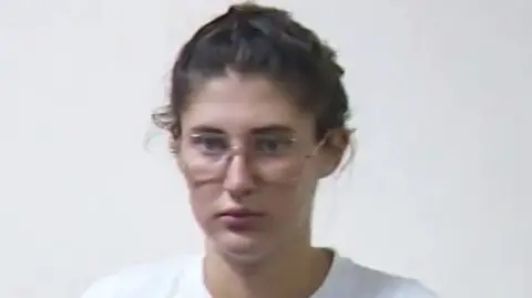 Bella Culley appearing in court, she has her hair tied back and is wearing glasses. She has a blank expression.