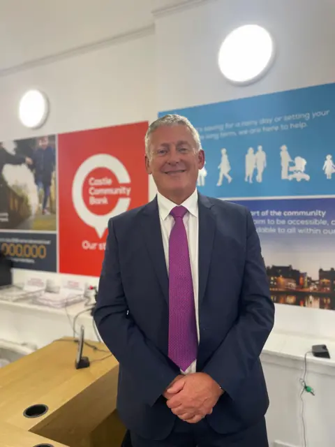 Steven Pearson from FIS Scotland wearing a dark suit and a purple tie