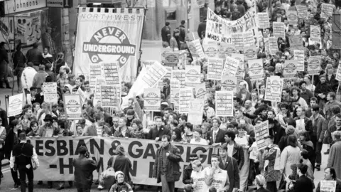 Getty Images A black and white image of a crowd of people demonstrating against Section 28 of the Local Government Act 1988.