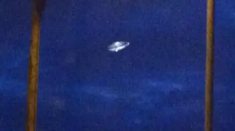 SEPI Agency A grainy image shows a classic "flying saucer" set against a dark blue sky.