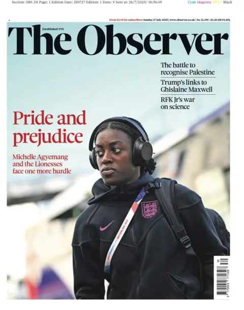 The Observer's front page is devoted to a picture of Lionesses player Michelle Agyemang. She wears a black jacket with purple insignia, and listens to headphones. A bag is slung over one shoulder. 