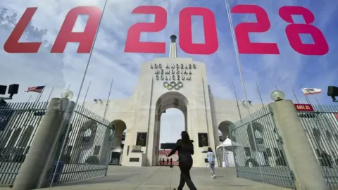 Getty Images A entrada do Los Angeles Memorial Stadium é refletida em uma janela "Los Angeles 2028" Escrito nele