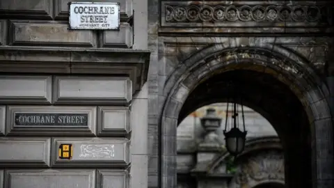 Getty Images An archway on Cochrane Street, with two signs - both displaying the street's name - visible.