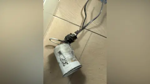 Liz Odell The burnt bathroom downlight lying on the tiled floor in Liz Odell's bathroom.