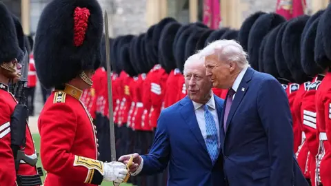US President Donald Trump, to King Charles' left, reviewing the Guard of Honour at Windsor Castle on in September 2025.