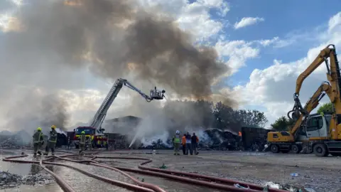 Derbyshire Fire and Rescue Service A ladder platform was being used to hose down burning waste