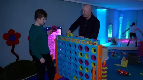 Matthew and his son George play a game of giant Connect Four together.