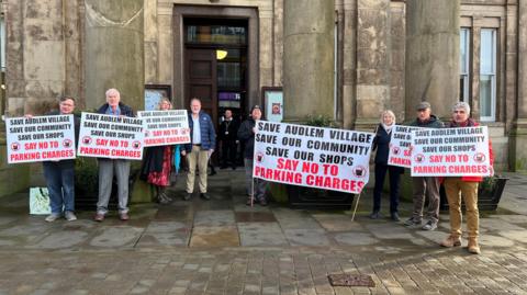 Protestors holding sign outside Macclesfield town hall