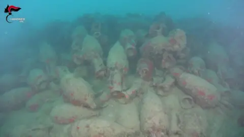 Dozens of barnacle-crusted jars seen on the sea bed