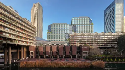 Skidmore, Owings & Merrill Flats in the Barbican housing estate and the City of London School for Girls are in the foreground, with an image the two towers of the new development in the background with two established taller towers on either side.