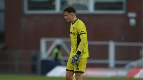 A photo of Jed Ward, wearing his yellow goalkeeping kit, playing for Yeovil Town during their match against Hartlepool in December