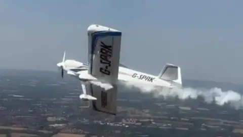 A plane at a display with smoke coming from the rear