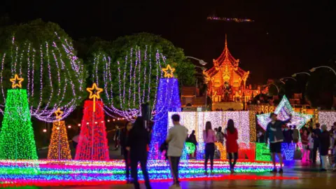 Getty Images A picture of Christmas lights, with some blurred images of people in the foreground