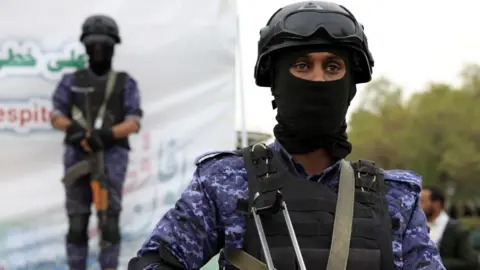 EPA A Houthi soldier stands in foreground, with a second Houthi soldier behind