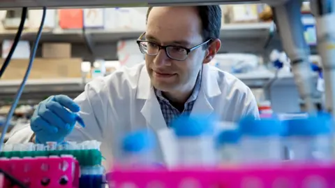 Memorial Sloan Kettering Cancer Center Dr. Daniel Heller looks at a small test tube 