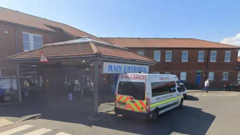 A Google Street View screenshot of the entrance to North Tyneside General Hospital, which is one of the hospitals managed by the trust. An ambulance is outside.