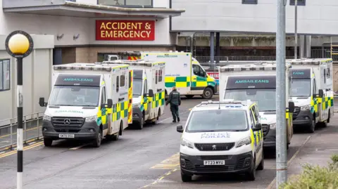 PA Ambulances and a police van line up on two sides of the road outside the Accident and Emergency Department at the Victoria Hospital in Kirkcaldy, Fife.