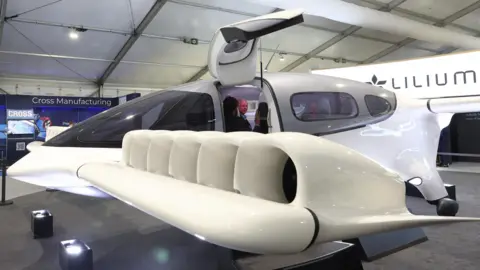 Reuters A Lilium electric vertical take off and landing (eVTOL) aircraft is displayed at Farnborough International Airshow, in Farnborough, Britain, July 24, 2024. 