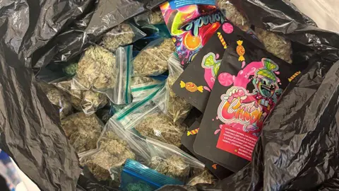 Greater Manchester Police A black bin bag with a large quantity of cannabis in clear plastic bags seized by police.