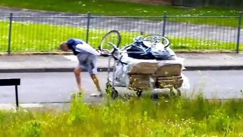 A man drags rubbish on a trolley