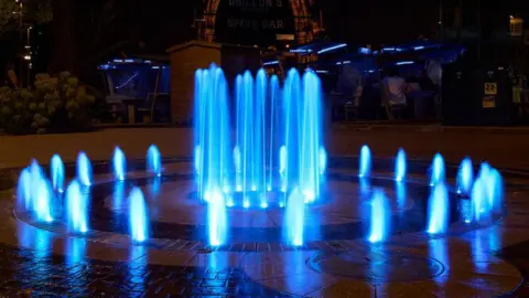 Coventry City Council A fountain lit up in sky blue lighting