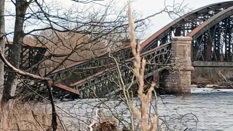 Roddy Robertson An iron girder bridge structure collapsed into a river