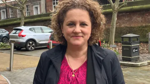 Deputy mayor of York and North Yorkshire Jo Coles. She is standing outside and is wearing a dark coat over a dark red dress