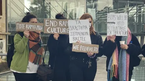 Protesters holding signs in support of woman outside court