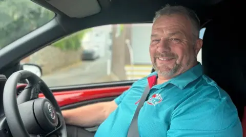 BBC Driving instructor Tom Burnett sat in a car behind the steering wheel