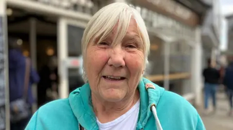 Sue Bristow standing near the site