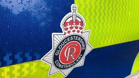 A shot of a Gloucestershire Constabulary police car's door with the force's crest on 