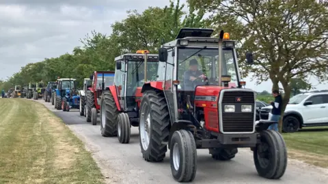 A long row of tractors snake along a road in Howden 