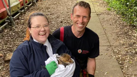 Essex County Fire & Rescue Service Two people holding a rescued fox
